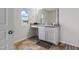 Well-lit bathroom with a window view, granite-look vanity, cabinet storage, and neutral flooring at 227 Sumter Ct, Burlington, NC 27217