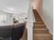 Open living room featuring carpeted stairs, neutral decor, and sightlines into the kitchen at 227 Sumter Ct, Burlington, NC 27217