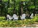 A relaxing seating area with Adirondack chairs in a lush backyard setting at 23 Great View Ct, Clayton, NC 27527