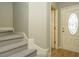 Welcoming foyer with carpeted stairs, neutral walls, and a glimpse of wood flooring leading to the entrance door at 23 Great View Ct, Clayton, NC 27527