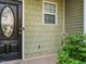 Close-up of the front entrance, showing the green shingle siding and a classic black door with oval glass at 23 Great View Ct, Clayton, NC 27527