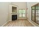 Bright living room featuring a fireplace, large windows with wooden blinds, and hardwood floors at 23 Great View Ct, Clayton, NC 27527