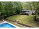Expansive backyard with a pool, firepit area, and lush greenery, perfect for entertaining and relaxation at 2312 Laurelford Ln, Wake Forest, NC 27587