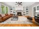 Inviting living room featuring a fireplace, built-in bookshelves, and hardwood floors perfect for relaxation and gatherings at 2312 Laurelford Ln, Wake Forest, NC 27587