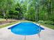 A refreshing in-ground swimming pool features a concrete patio area for relaxing and enjoying the sun at 2312 Laurelford Ln, Wake Forest, NC 27587