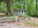 Backyard shed offers storage and functionality, surrounded by trees and lush landscaping at 2312 Laurelford Ln, Wake Forest, NC 27587