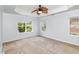 Relaxing main bedroom with tray ceiling, fan, and large windows overlooking a green and leafy backyard at 2437 Everstone Rd, Wake Forest, NC 27587