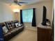 Living room with brown leather sofa, ceiling fan, and carpeted floor creating a cozy atmosphere at 2528 Beech Gap Ct, Raleigh, NC 27603