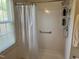 Shower with white tile and a safety grab bar, plus a shower head and shelving at 2528 Beech Gap Ct, Raleigh, NC 27603