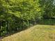 Fenced backyard featuring a grassy yard and lush trees at 2565 Bent Green St, Raleigh, NC 27614