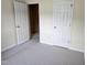 Cozy bedroom showcasing neutral carpeting, white trim and two conveniently placed doors at 2565 Bent Green St, Raleigh, NC 27614