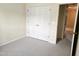 Well-lit bedroom featuring neutral carpeting, a closet, and a view into the hallway at 2565 Bent Green St, Raleigh, NC 27614