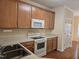 Kitchen with wood cabinets, white appliances, and neutral countertops at 2565 Bent Green St, Raleigh, NC 27614