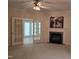 Living room with carpet, ceiling fan, fireplace, and view into a sunroom at 2565 Bent Green St, Raleigh, NC 27614
