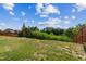 Wide backyard featuring a lush green lawn, mature trees, and a wooden fence creating a private outdoor space at 270 Oak Park Blvd, Youngsville, NC 27596