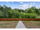 Backyard featuring a gated entrance and steps leading down to a wooded area, enhancing privacy at 270 Oak Park Blvd, Youngsville, NC 27596