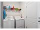 Functional laundry room features a side-by-side washer and dryer, and shelving for storage at 270 Oak Park Blvd, Youngsville, NC 27596