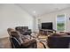 Bright living room with cozy seating, large TV, wood-look floors, and ample natural light from the window at 270 Oak Park Blvd, Youngsville, NC 27596