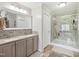 Stylish bathroom with a double sink vanity, modern lighting, and a glass-enclosed shower with decorative tile accents at 2705 Flat Rock Rd, Franklinton, NC 27525