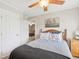 Cozy bedroom features neutral colors, ceiling fan, side table with lamp and walk through to another room at 2705 Flat Rock Rd, Franklinton, NC 27525