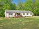 Inviting one-story home with well maintained lawn, a front porch, and surrounded by green trees at 2705 Flat Rock Rd, Franklinton, NC 27525