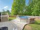 Backyard pool area with above-ground pool surrounded by a custom-decorated pool, deck, and landscaped yard at 2705 Flat Rock Rd, Franklinton, NC 27525