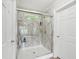 Elegant bathroom shower with glass doors, marble-like walls, built-in shelves, and a window providing natural light at 2705 Flat Rock Rd, Franklinton, NC 27525