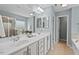 Bathroom with dual sinks, a large mirror, and an access to a separate shower and bathtub at 2728 Evanston Ave, Durham, NC 27703