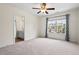 Large bedroom featuring a ceiling fan, neutral carpet, and a view into the bathroom at 2728 Evanston Ave, Durham, NC 27703