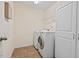 A laundry room featuring a washer, dryer, overhead shelving, and storage cabinet at 2728 Evanston Ave, Durham, NC 27703