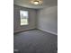 Bright bedroom featuring neutral walls, carpet floors, and a window overlooking the yard at 29 High Hampton Way, Fuquay Varina, NC 27526