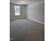 Bright bedroom featuring neutral walls, carpet floors, and a window overlooking the yard at 29 High Hampton Way, Fuquay Varina, NC 27526