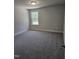 Bright bedroom featuring neutral walls, carpet floors, and a window overlooking the yard at 29 High Hampton Way, Fuquay Varina, NC 27526