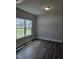 Empty room with dark floors, a large window, and light gray walls at 29 High Hampton Way, Fuquay Varina, NC 27526