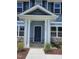 Charming home entrance with a blue door, stone accents, and a covered porch at 29 High Hampton Way, Fuquay Varina, NC 27526