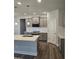 Modern kitchen featuring gray cabinets, stainless steel appliances, and a center island with a sink at 29 High Hampton Way, Fuquay Varina, NC 27526