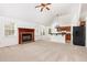 Open living room featuring a cozy fireplace, neutral carpeting, and easy access to kitchen at 300 Ravenstone Dr, Cary, NC 27518
