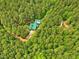 An aerial shot of a beautiful house with a green roof nestled in a lush forest at 3009 Pleasant Hill Church Rd, Siler City, NC 27344