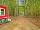 Backyard view with a red chicken coop, gated entry, and trees at 3009 Pleasant Hill Church Rd, Siler City, NC 27344