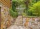 Stone steps lead to a lush backyard garden with mature trees and vines at 3009 Pleasant Hill Church Rd, Siler City, NC 27344