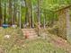 Backyard wooden staircase leading up a hill with lush greenery and a shed at 3009 Pleasant Hill Church Rd, Siler City, NC 27344