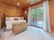 Charming bedroom with wood paneling and sliding glass doors leading to an outdoor deck at 3009 Pleasant Hill Church Rd, Siler City, NC 27344