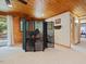 Cozy bedroom with wood paneling, divider screen, and access to an outdoor deck at 3009 Pleasant Hill Church Rd, Siler City, NC 27344