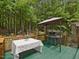 Outdoor deck with wooden railing, table and chairs, and grill, perfect for enjoying the outdoor scenery at 3009 Pleasant Hill Church Rd, Siler City, NC 27344