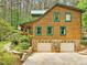 Exterior of log home with stone foundation, two-car garage, and mature trees at 3009 Pleasant Hill Church Rd, Siler City, NC 27344