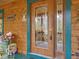 Detailed glass front door framed by log siding and trimmed with decorative accents at 3009 Pleasant Hill Church Rd, Siler City, NC 27344