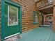 Charming log home front door with decorative glass, painted trim, and covered porch entry at 3009 Pleasant Hill Church Rd, Siler City, NC 27344