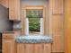 Kitchen window nook with custom seat featuring scenic outdoor views and wooden cabinetry for storage at 3009 Pleasant Hill Church Rd, Siler City, NC 27344