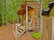 Wooden outbuilding with covered porch and stairs in wooded backyard at 3009 Pleasant Hill Church Rd, Siler City, NC 27344