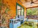 Cozy covered porch features comfortable seating, a ceiling fan, and wooden log walls at 3009 Pleasant Hill Church Rd, Siler City, NC 27344